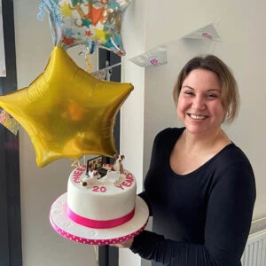 Lynn celebrates 20 years at village vet cambridge lynn with cake and balloon 300x300